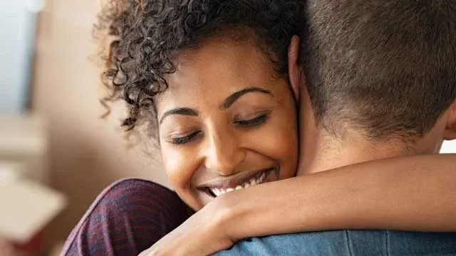 Woman smiling giving someone a hug